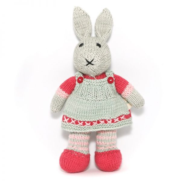 Image of hand knitted bunny Merinda with pale sage dress, raspberry jersey and shoes as well as pink and pale sage striped socks and raspberry detail on dress